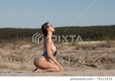 Sensual young lady in bikini enjoying sunny day on sandy beach Sensual young lady in bikini enjoying sunny day on sandy beach 79121618