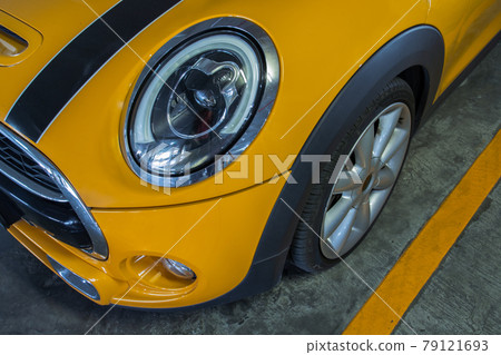 Close-up of Headlights, Wheel, and Rim of Yellow car. Close-up of Headlights, Wheel, and Rim of Yellow car. 79121693