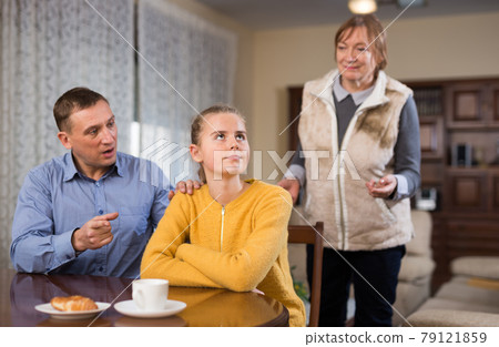 Woman and man lecturing teenage girl 79121859