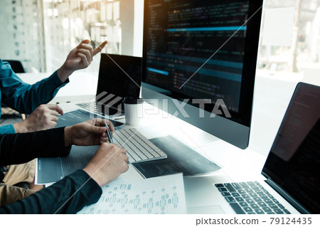 Two partnerships developing programming and coding technologies working on laptop and analyzing together. 79124435