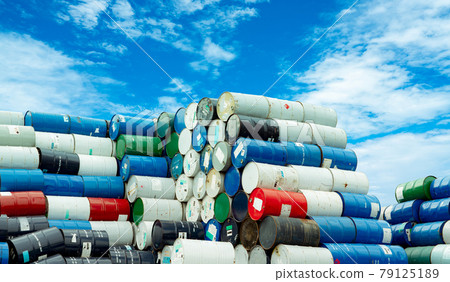 Old chemical barrels. Hazard chemical barrel with warning label. Blue, green, white and red oil drum. Steel oil tank. Toxic waste warehouse. Hazard waste storage in factory. Metal brent oil drum. 79125189