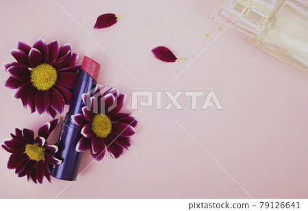 Red lipstick in chrysanthemum flowers, perfume. Pink background - space for text. Beauty, beauty and care 79126641