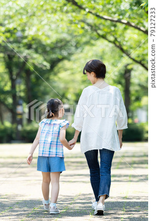 Back view of parents and children walking hand in hand 79127233