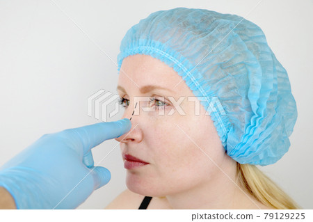 Rhinoplasty: patient on admission to a plastic surgeon. She has to go through the nose Rhinoplasty: patient on admission to a plastic surgeon. She has to go through the nose 79129225