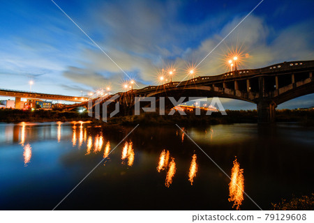 橋上路燈閃爍,水面倒影美麗。天上雲層厚厚,河面水流高漲,氣息濃鬱。 橋上路燈閃爍,水面倒影美麗。天上雲層厚厚,河面水流高漲,氣息濃鬱。 79129608