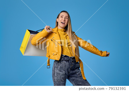 woman in leather jacket holding shopping bag with purchases woman in leather jacket holding shopping bag with purchases 79132391