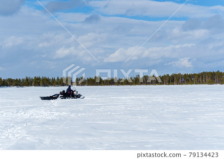 snowmobile fisherman is riding along the winter lake. landscape winter photo snowmobile fisherman is riding along the winter lake. landscape winter photo 79134423