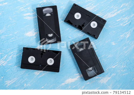 old vhs video cassettes on a blue background. Top view. old vhs video cassettes on a blue background. Top view. 79134512