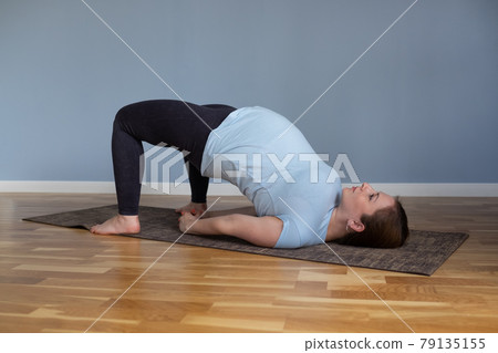 Pregnant happy fitness person enjoy yoga practice at home. 79135155