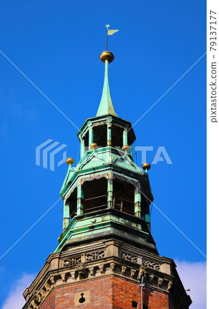 Close-up on the spire of an old church or cathedral against the blue sky. 79137177