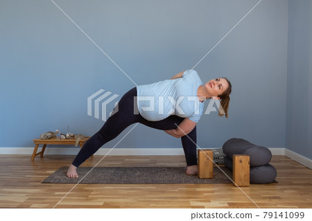 woman practicing yoga, doing lunge exercise, Side Angle Pose, Parsvakonasana, 79141099