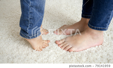 Barefoot little boy standing on tiptoe and reaching his mother Barefoot little boy standing on tiptoe and reaching his mother 79141959