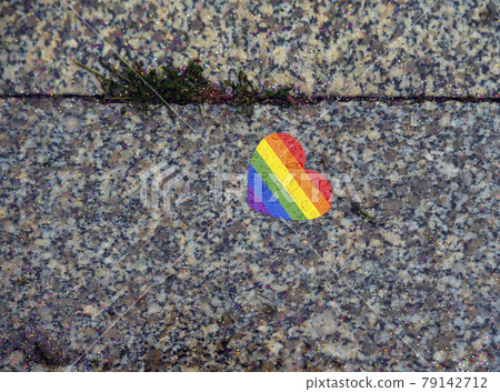 Heart with rainbow colors after lgbt parade and rain on the ground from above 79142712