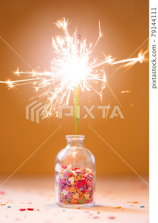 Burning sparkler in a bottle with colorful sprinkling, festive celebration party concept Burning sparkler in a bottle with colorful sprinkling, festive celebration party concept 79144111