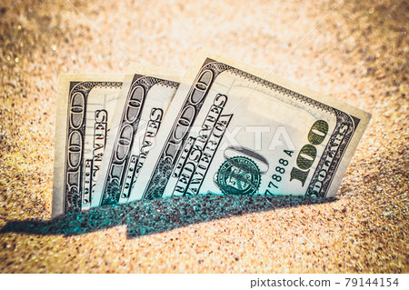 Money dolars half covered with sand lie on beach close-up. 79144154