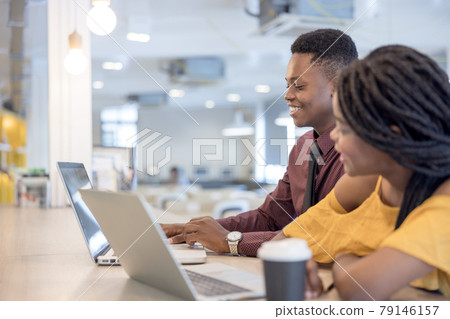 african college university students using laptop together . 79146157