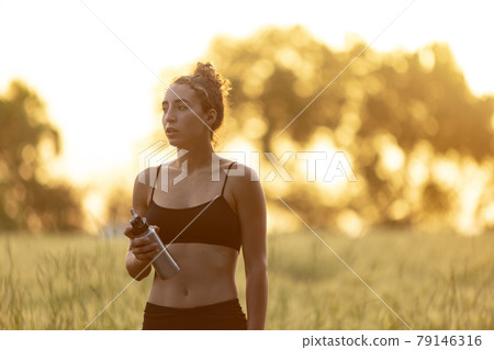 Young female runner, athlete is jogging at road in summer sunshine. Beautiful caucasian woman training, listening to music. Concept of sport, healthy lifestyle, movement, activity. Young female runner, athlete is jogging at road in summer sunshine. Beautiful caucasian woman training, listening to music. Concept of sport, healthy lifestyle, movement, activity. 79146316