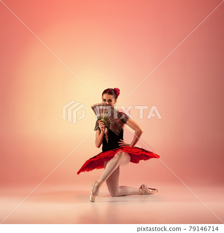 Young and incredibly beautiful ballerina is posing and dancing at red studio full of light. 79146714