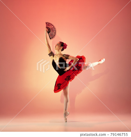 Young and incredibly beautiful ballerina is posing and dancing at red studio full of light. 79146755