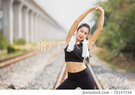 Woman tan skin in black sportswear outdoor physical exercises for successful health at railway. Woman tan skin in black sportswear outdoor physical exercises for successful health at railway. 79147594