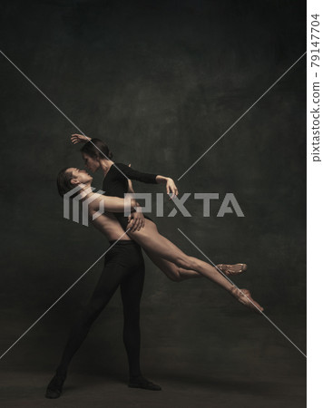 Beautiful graceful woman and man, ballet dancers in art performance dancing isolated over dark background 79147704