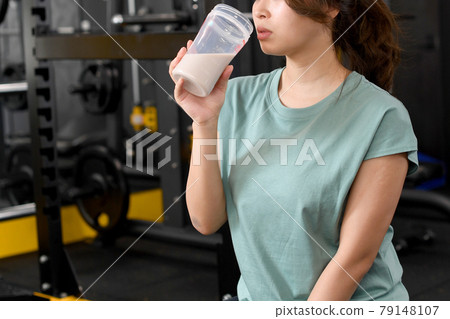 婦女在健身房喝蛋白質 婦女在健身房喝蛋白質 79148107