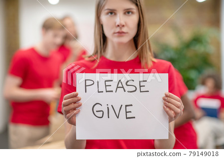 Girl volunteer with poster in her hands 79149018