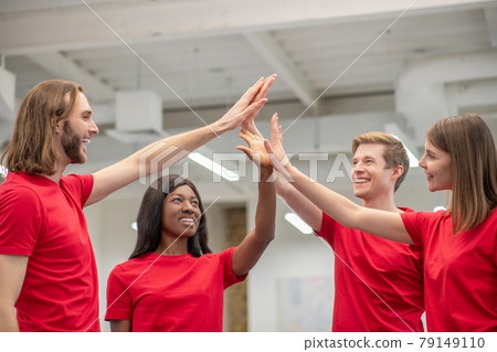 Two girls and guys touching palms of raised hands Two girls and guys touching palms of raised hands 79149110