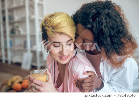 African American woman touching face of caucasian girlfriend African American woman touching face of caucasian girlfriend 79149146