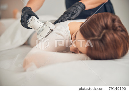 Cosmetologist using professional skincare at beauty salon 79149190