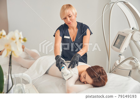 Professional beautician caring about skin of client 79149193