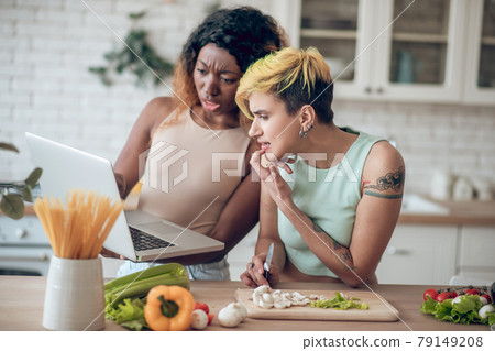 Emotional questioning girlfriends looking indignant at laptop Emotional questioning girlfriends looking indignant at laptop 79149208