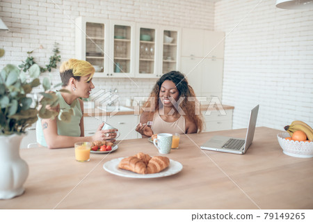 Caucasian woman and dark skinned breakfast communicating Caucasian woman and dark skinned breakfast communicating 79149265