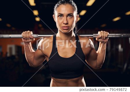 Determined beautiful sportswoman weightlifting at the gym 79149872