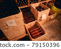 Wooden crates with bottles of wine in storage room 79150396