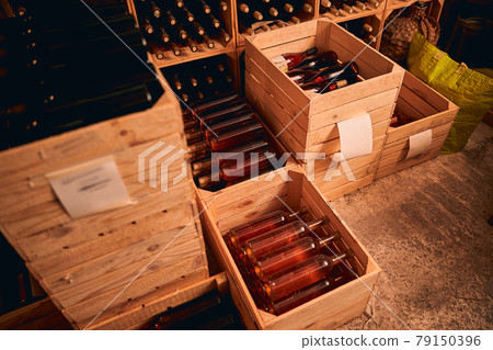 Wooden crates with bottles of wine in storage room 79150396