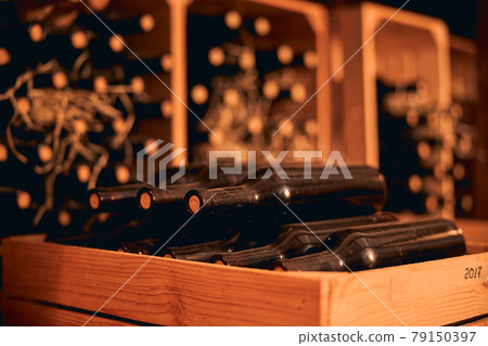 Dusty bottles of red wine in wooden crate Dusty bottles of red wine in wooden crate 79150397