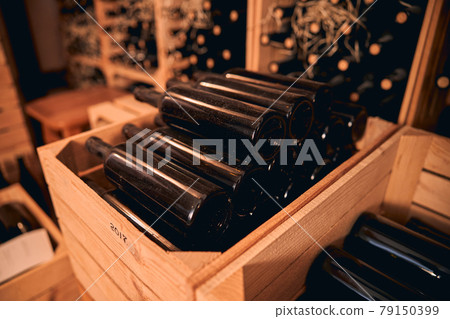 Dusty bottles of wine in storage room or wine cellar Dusty bottles of wine in storage room or wine cellar 79150399