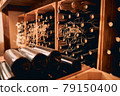Wooden racks with wine bottles in storage room 79150400