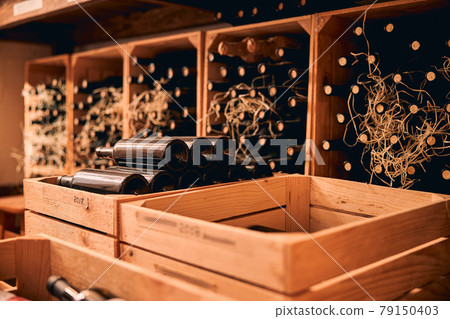 Wooden crates with glass wine bottles in wine cellar Wooden crates with glass wine bottles in wine cellar 79150403