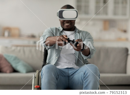 African american millennial man relax in living room interior, play video game, using gamepad African american millennial man relax in living room interior, play video game, using gamepad 79152313