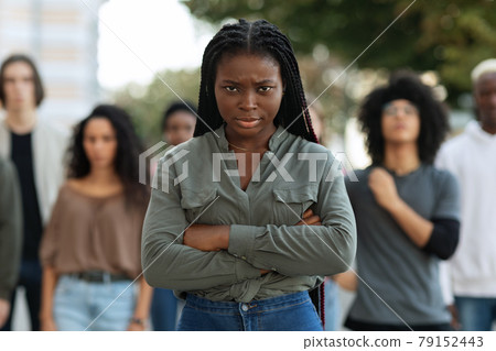 Closeup of angry black lady over demonstrators making riot outdoors Closeup of angry black lady over demonstrators making riot outdoors 79152443