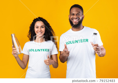 Two Volunteers Holding Glass And Plastic Bottles, Yellow Background 79152483