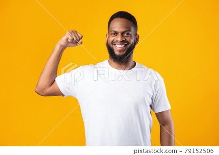 Cheerful Black Guy Showing Biceps Muscles Posing On Yellow Background Cheerful Black Guy Showing Biceps Muscles Posing On Yellow Background 79152506