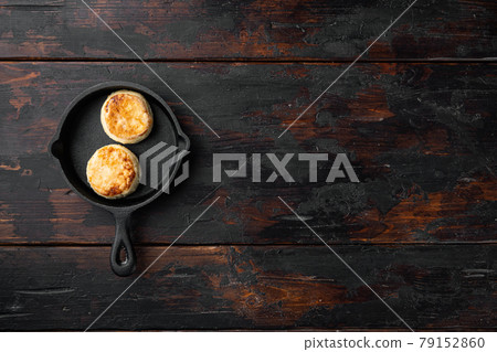 Cheese cakes Sweet pancakes on cast iron frying pan skillet on cast iron frying pan skillet, top view flat lay, on black wooden table background, with copy space for text 79152860