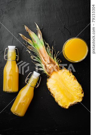 Fresh pineapple juice, on black dark stone table background, top view flat lay 79153304