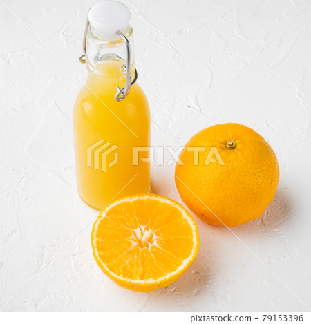 Glass jar of fresh Tangerine juice, square format, on white stone table background Glass jar of fresh Tangerine juice, square format, on white stone table background 79153396