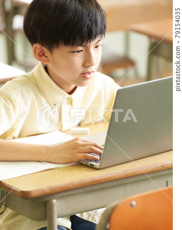 Elementary school students using a computer in the classroom 79154035