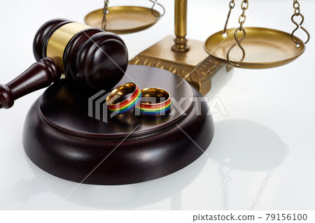 Two gold wedding rings with lgbt rainbow colours. Homosexual marriage. Lgbt rights and law. Two gold wedding rings with lgbt rainbow colours. Homosexual marriage. Lgbt rights and law. 79156100