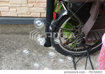 Play with soap bubbles in front of the house Play with soap bubbles in front of the house 79156942